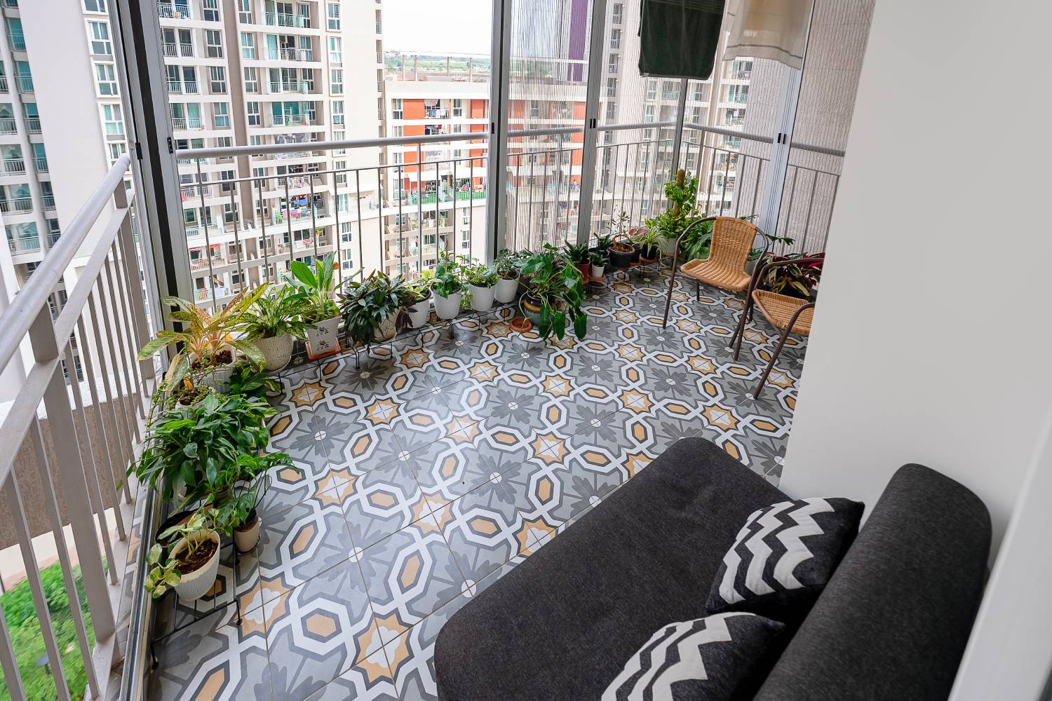 Modern Balcony Design with Green Plants, Wicker Chairs and Tiles | Livspace