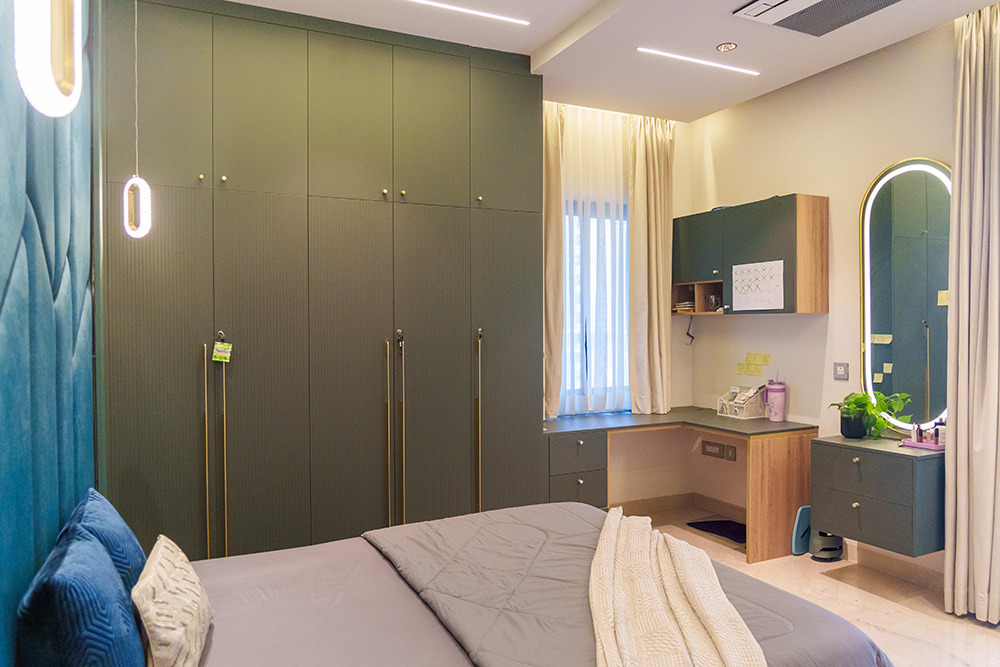 Modern full-height wardrobe with green finish and integrated dressing area